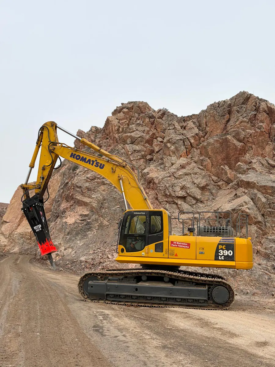 Tracked excavator using a hydraulic breaker at the quarry rock face